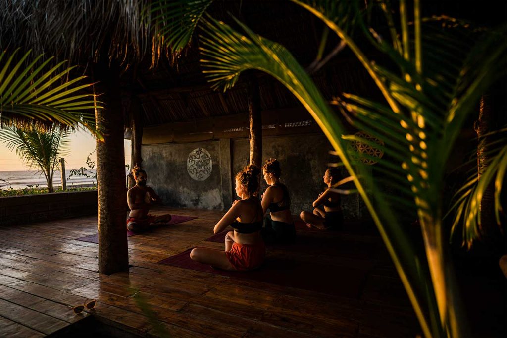 A group of yogis at Alive Beach House close their practice with the Anjali mudra