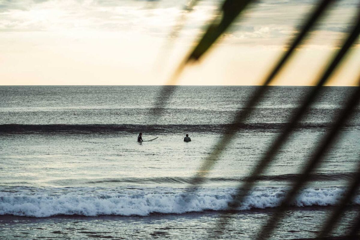 Two surfers wait to catch a wave outside of Alive Beach House hotel in El Transito Nicaragua