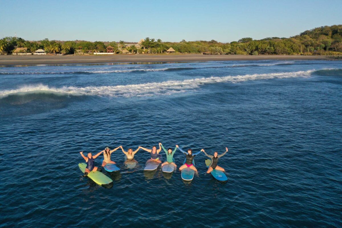girls surfing the waves in front of alive